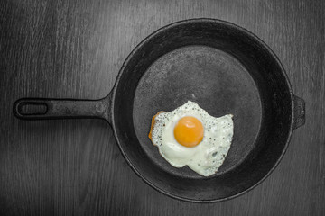 pan with fried eggs on a wooden background