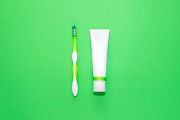 Toothpaste and toothbrush on green background. Healthy teeth concept