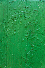 Wooden door texture with green paint is severely weathered and peeling