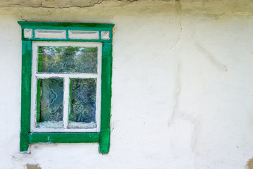 Background texture concept. Old grungy window with green painted decoration around and white curtains inside in white cement wall.