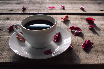 White coffee cup decorate with red dry rose on wood plate,vintage concept.