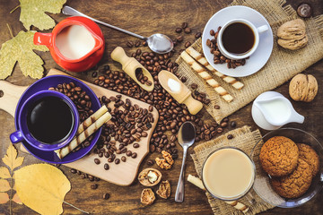 cups with coffee. grains of coffee, biscuits. wooden background.