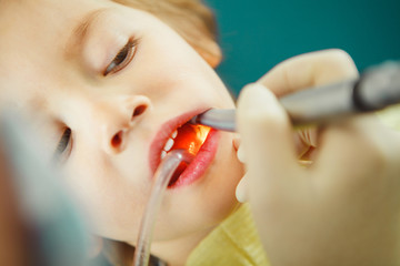 Close up shot of little boy in dentist chair during drilling and dental treatment.