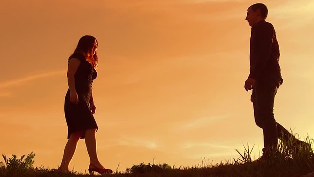 silhouette of a couple at sunset. Man and woman silhouette in sunset slow motion. Couple in love kissing at sunrise. man and girl lifestyle embrace silhouette family concept