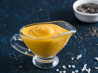 Creamy Cheddar sauce with chia seeds on dark background.Ideas and recipe for healthy diet or vegan food.Homemade Chia Cheeze Sauce for snacks,tacos,nachos,dipping,mac-n-cheese,base for pizza.Copyspace