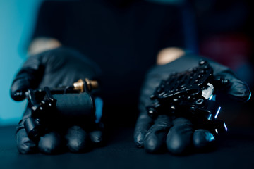 Woman master holding tattoo machine, preparing for drawing picture