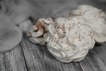 White Meringue Cookies. Sweet Desert over Gray rustic Wooden Board in Black Plate.