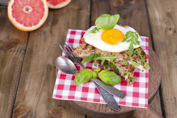 Sandwich of corn bread with egg and ham for breakfast. A healthy and delicious breakfast. Wooden background. Fitness food, toast. Horizontal photo