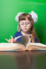 Little girl with white bows watching book