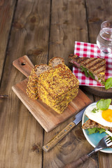Sandwich of corn bread with egg and ham for breakfast. Grilled food. A healthy and delicious breakfast and coffee. Wooden background. Place for text