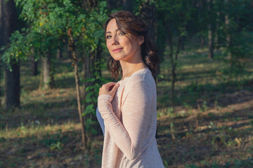 Obraz premium Beautiful woman lit by the sun in the park. People