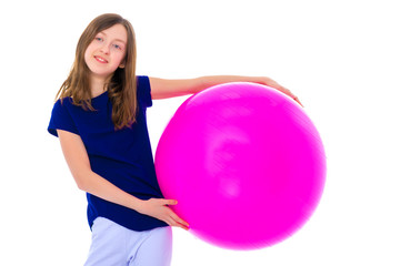 little girl is engaged in fitness with a ball.