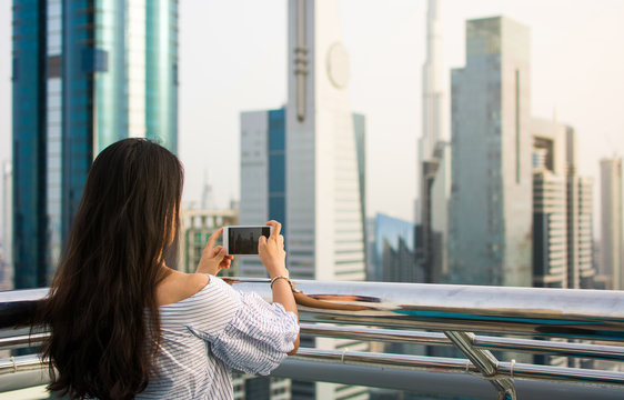 Girl taking picture of Dubai cityscape