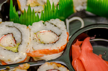 Close up of selective focus of japanese sushi rolls on a black plastic plate