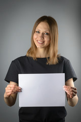 Naklejka premium A woman holds white sheet of paper