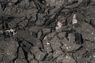 Old cracked asphalt road scrapheap damage on the ground to be recycled.concept for the reduce reuse and recycle.close-up of old cracked asphalt .Select focus. Gray texture background
