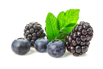 Fresh ripe blueberries and blackberries with leaves close up isolated on white background. Healthy food.