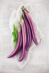 Fresh, beautiful purple violet eggplants decorated on a white wood table, studio shoot can be used as background 