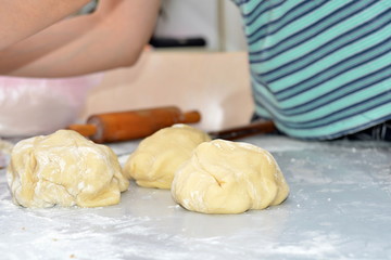 The dough is on the table, the flour is ready to be baked for pies and rolls