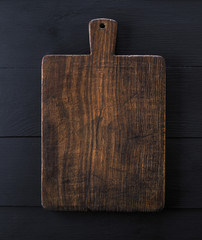 very old brown kitchen cutting board with handle