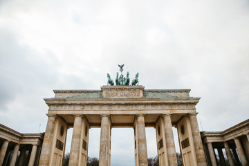 Fototapeta premium Brandenburg gate in Berlin, Germany or Federal Republic of Germany. Architectural monument in historic center of Berlin. Symbol and monument of architecture.