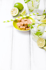 Summer refreshing cocktail mojito with lime and mint on white wooden vintage background.