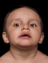 Close up of beautiful little boy portrait on dark background