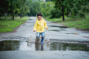 Little boy playing in puddle
