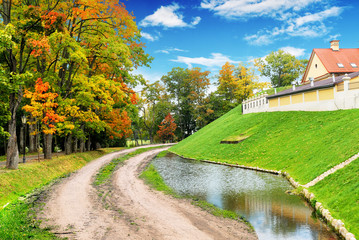 Pond with a forest and hill with castle buildings against sky with clouds