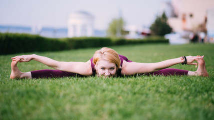 girl doing yoga on green grass on a sunny day