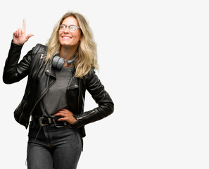 Young student woman with headphones pointing away side with finger