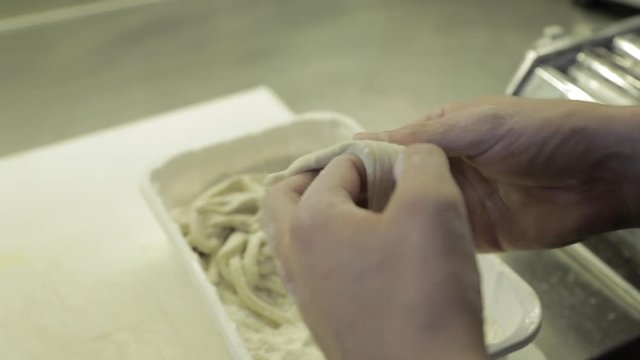 Close up, chef separates pasta dough