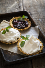 Homemade tart with berries and icing, cream, whipped cream. Open pie with  cream. Summer baking, summer food, wedding dessert..Lily of the valley. Process of decoration food. Baking process. Breakfast