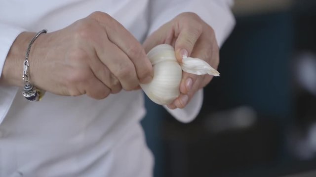 Close up, chef cuts into garlic