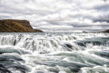 River rapids in reykjavik, iceland. Water stream flow. Water falls on cloudy sky. Velocity and turbulence. Wild nature landscape. Wanderlust and vacation