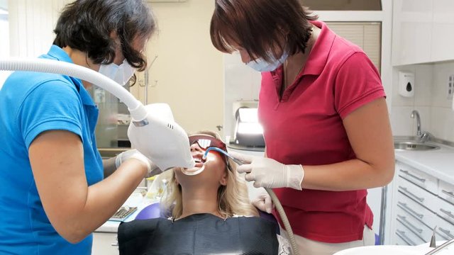 4k footage of dental nurse helping dentist treating patient's teeth
