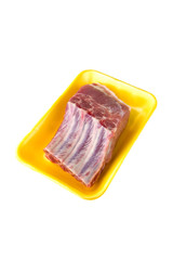 A piece of raw pork meat in a plastic container. A piece of meat with ribs in a container on a white background.