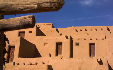 Pueblo with wood timbers out of focus in the foreground for feeling of depth