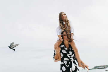 Mother and daughter holding hands and walking on beach. Mom and dauther happy family lifestyle concept