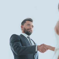 Two business workers shake hands in office