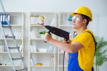 Young repairman with power drill