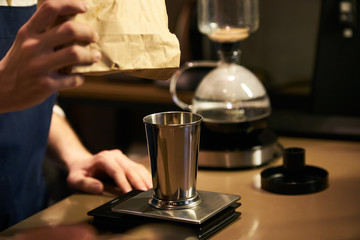 Barista weighs coffee on scales before preparing espresso. Professional barista equipment prepare for brewing drip coffee