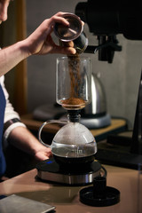 Fototapeta na wymiar Barista weighs coffee on scales before preparing espresso. Professional barista equipment prepare for brewing drip coffee