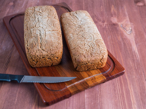 Fresh bread  and cutting knife on rustic table