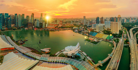 Panorama of Singapore Marina Bay with Financial District skyscrapers at sunset light reflected on the harbor. Roof top with Singapore skyline. Singapore cityscape aerial view. - obrazy, fototapety, plakaty
