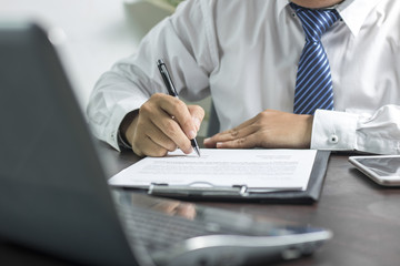 businessman or lawyer signing on contract paper on table in office, concept as insurance