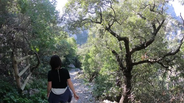 young woman alone strolling on a mediterranean path in the canyon of galamus, Pyrenees orientales in southern of France

