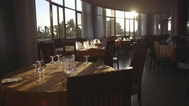 Pan left, sun shines through empty restaurant