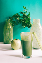 Healthy green smoothie with kale banana and date in glass against a green background. Detox, diet, healthy, vegetarian food concept with copy space.+