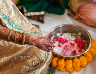 close up of Hindu bride with henna and bowl of petals